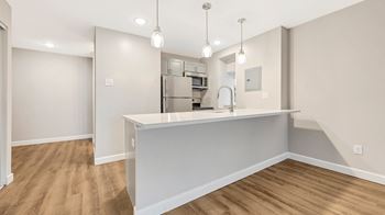 A kitchen with a large island and a stainless steel refrigerator